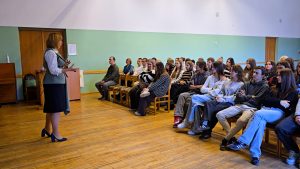 Lektore runā ar skolēniem par datu drošību un privātumu skolas aktu zālē.
