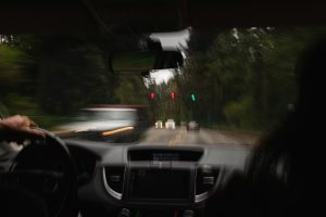 Neskaidra, izplūdusi satiksmes aina skatāma no auto vadītāja perspektīvas — simbolizē reibuma ietekmi uz uztveri.