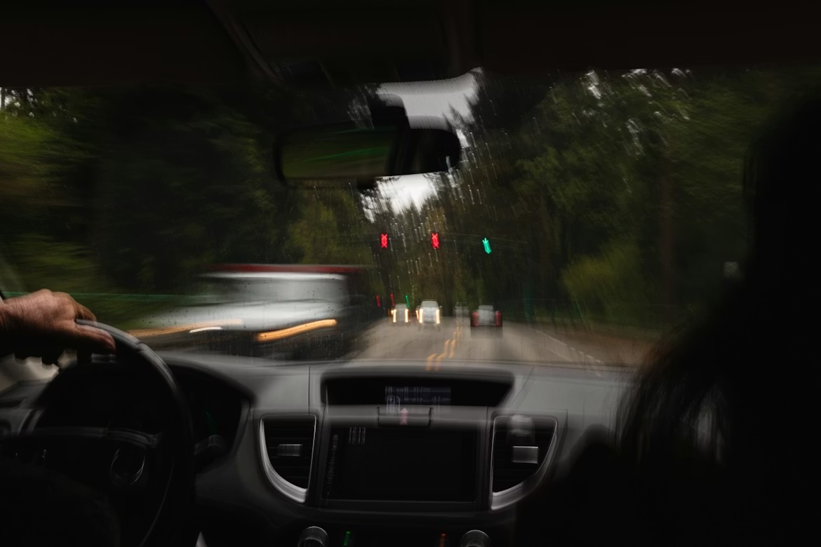 Neskaidra, izplūdusi satiksmes aina skatāma no auto vadītāja perspektīvas — simbolizē reibuma ietekmi uz uztveri.