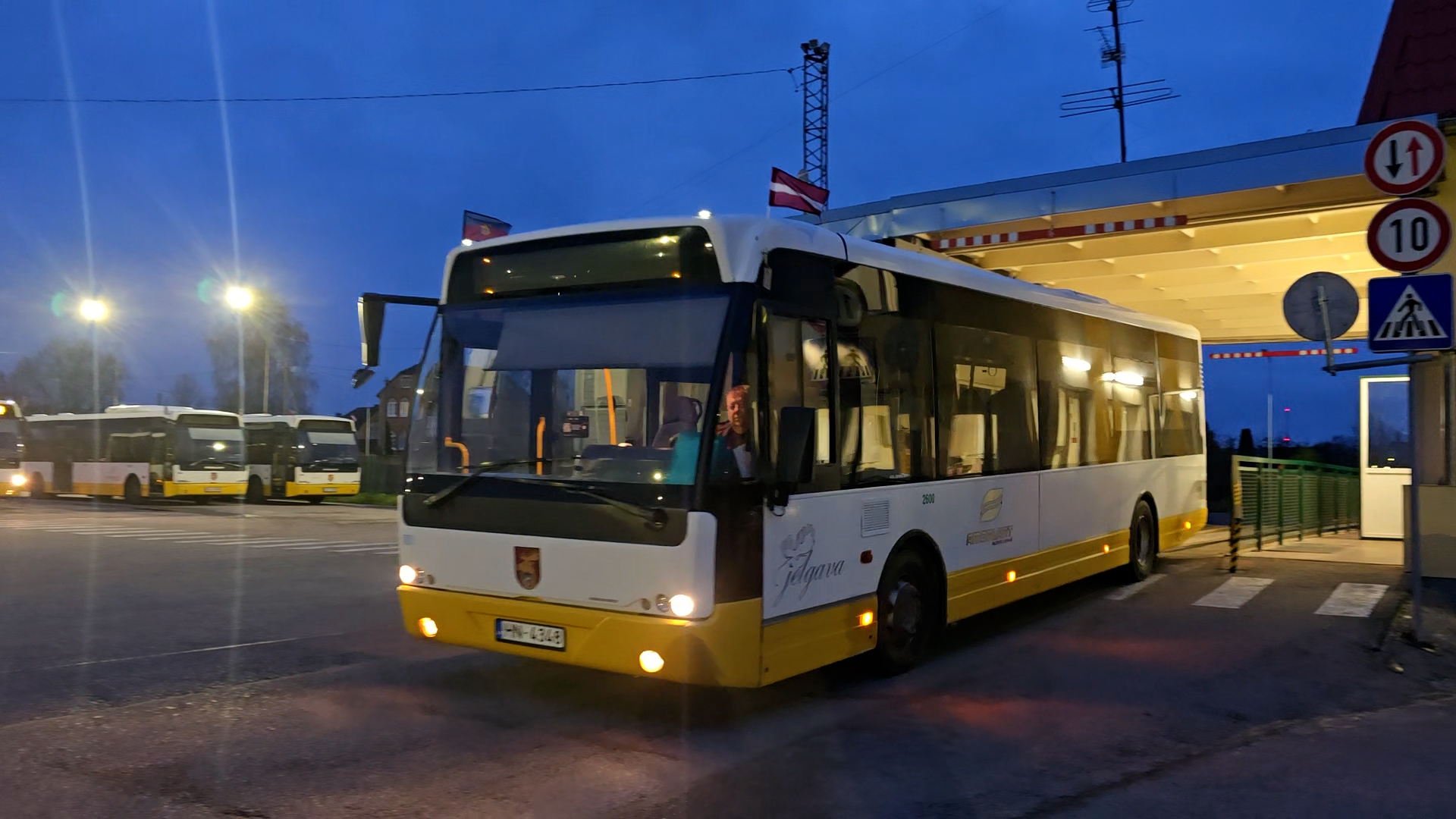 Jelgavas pilsētas autobuss vakarā pie autobusu parka ēkas.