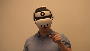 Cilvēks ar virtuālās realitātes brillēm testē VR tehnoloģiju telpā.
