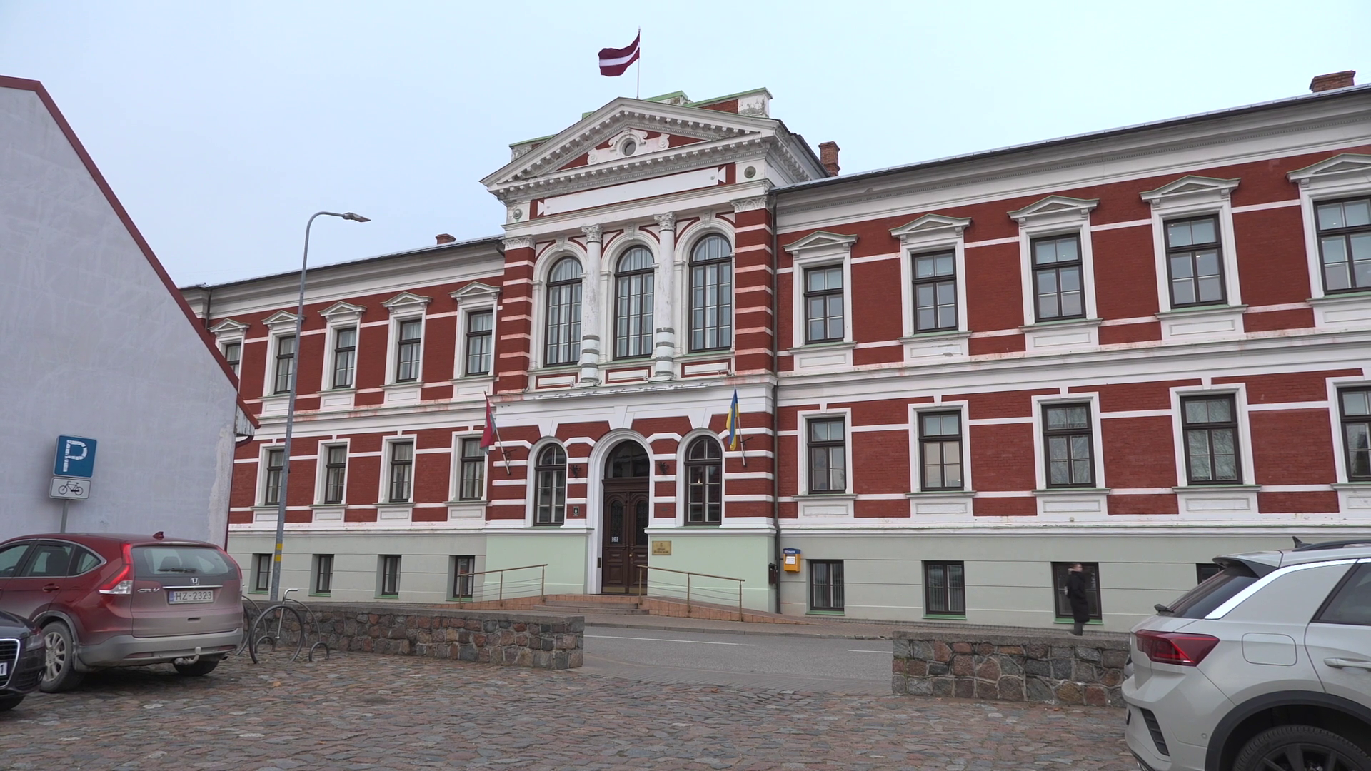 Liepājas domes ēka ar Latvijas karogu fasādes augšdaļā.