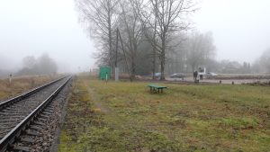 Jaungulbenes dzelzceļa stacijas apkārtne ar sliežu ceļu miglainā rītā.