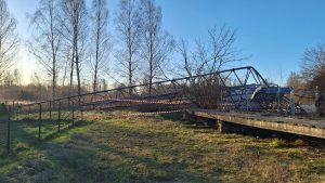 Nogāzts apraides sakaru tornis ar metāla konstrukciju pie ēkas