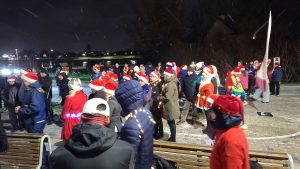 Ziemassvētku skrējiens ar dalībniekiem Ziemassvētku cepurēs vakarā