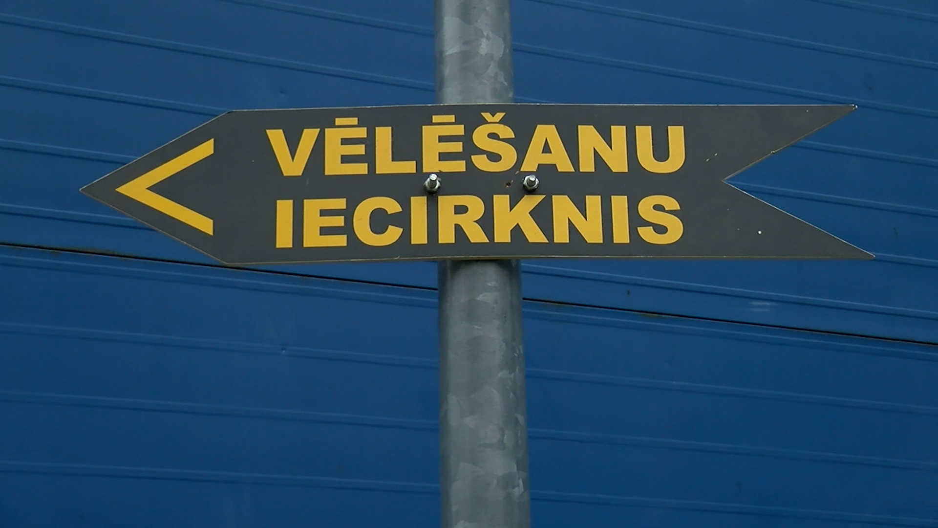Norādes zīme ar uzrakstu “Vēlēšanu iecirknis” un bultiņu pa kreisi