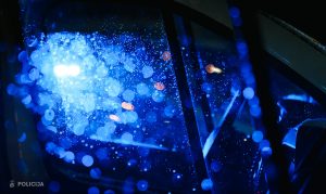 Zilu policijas bākugunīm raksturīgs gaismas atspīdums uz aizsaluša vai mitra stikla.