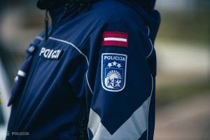 Valsts policijas darbinieka formas tērpa detaļas ar uzšuvi un Latvijas karogu.