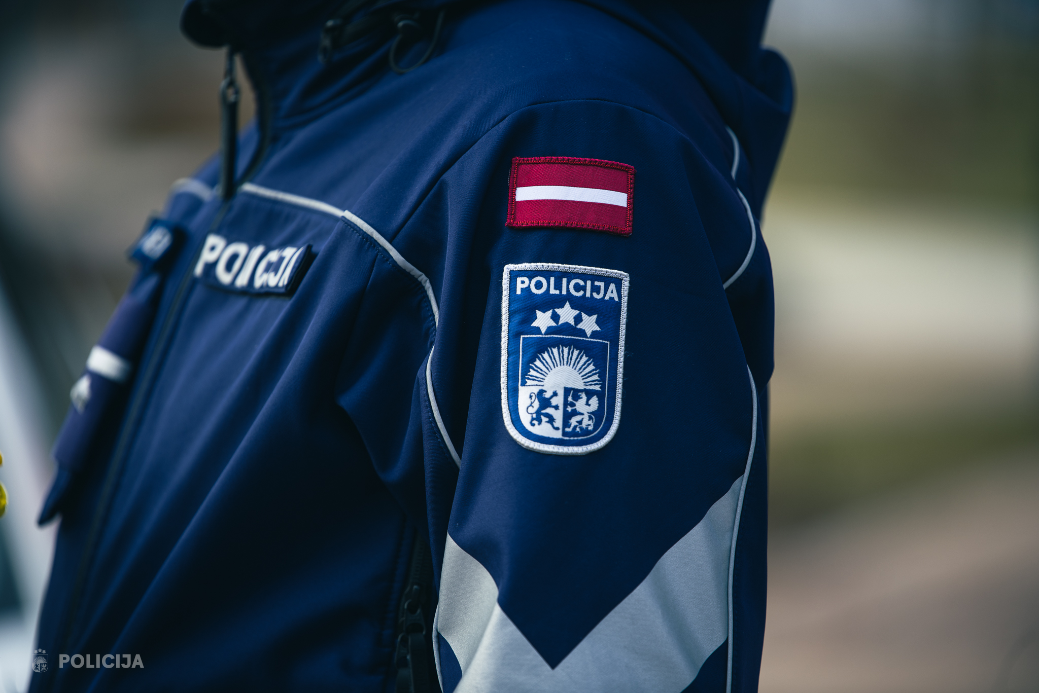 Valsts policijas darbinieka formas tērpa detaļas ar uzšuvi un Latvijas karogu.