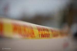 Mākslinieciski izplūdusi Valsts policijas dzeltenā drošības lenta.