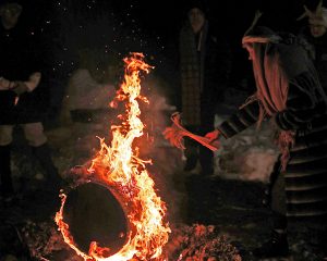Bluķa vakars ar ugunskuru un tradicionāli tērptiem dalībniekiem ziemas rituālā.