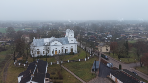 Skats no putna lidojuma uz balto baznīcu Latvijas mazpilsētā miglainā laikā