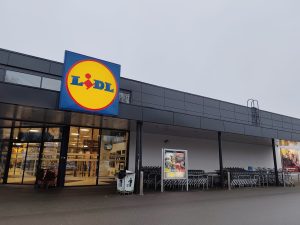 Veikala "Lidl" ēkas fasāde ar pamanāmu zīmola logotipu virs ieejas.