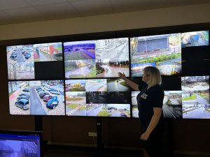 Pašvaldības video novērošanas telpa ar ekrānu sienu, kurā redzami satiksmes un pilsētvides kameru skati.