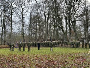 Karavīru ierinda svinīgā militārā ceremonijā brīvā dabā.