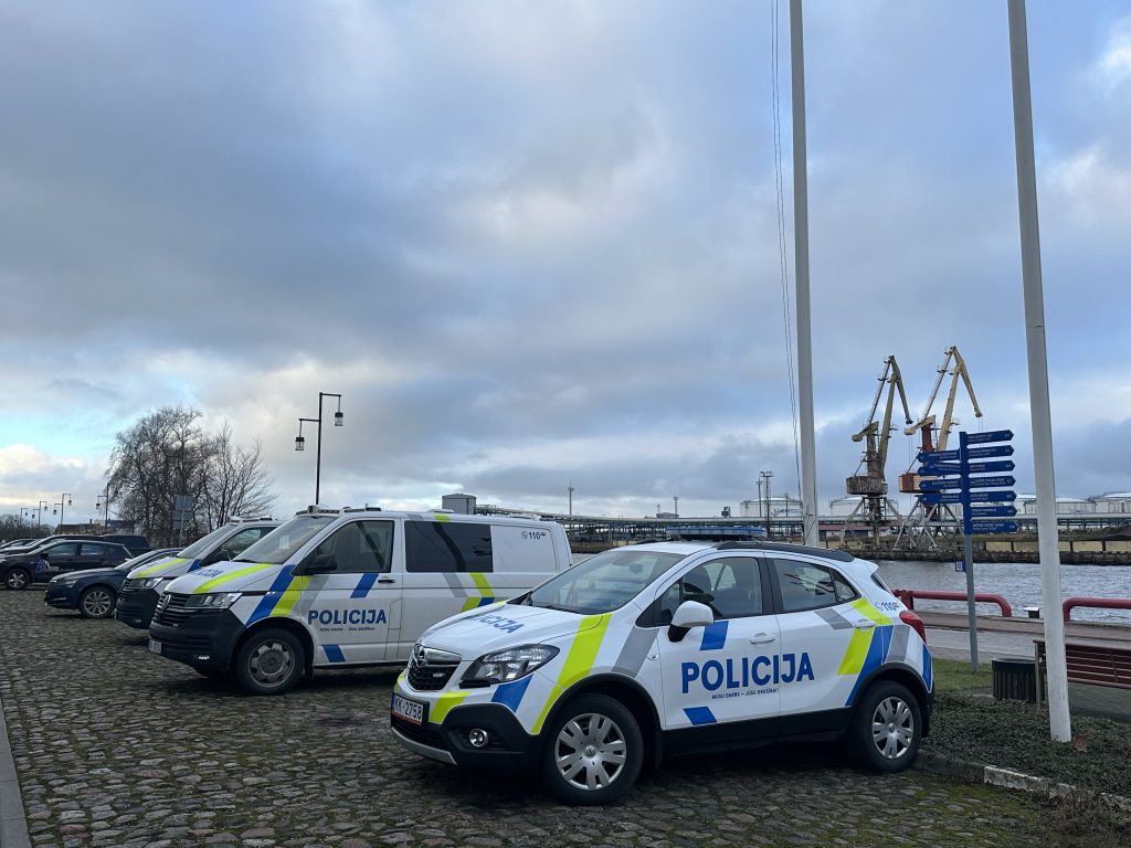 Pašvaldības policijas un Valsts policijas automašīnas stāvvietā pie ostas krāniem.