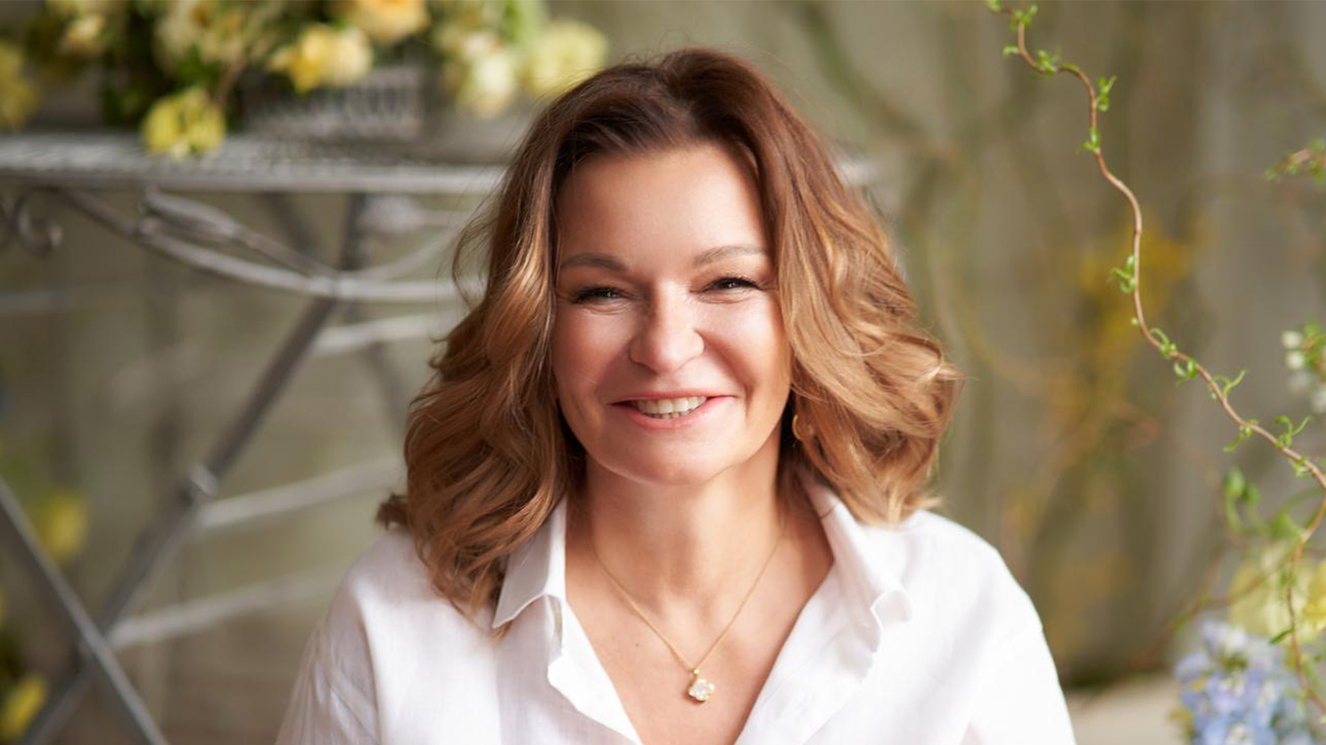 Psiholoģe un geštaltterapeite Ivonna Ķezbere smaidot portreta foto gaišā, dabiskā interjerā.