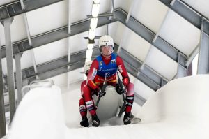Latvijas kamaniņu sporta divnieks pilnā ātrumā traucas pa Siguldas trasi sacensību laikā.