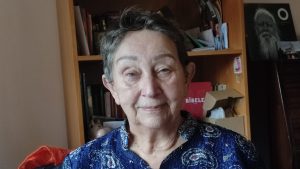 Kuldīgas homeopāte Mārīte Merga savā darba telpā pie grāmatplaukta.