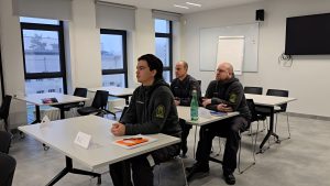 Ieslodzījuma vietu darbinieki sēž mācību telpā un piedalās profesionālās apmācībās.