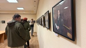 Apmeklētāji aplūko Zemessardzes 56. kaujas nodrošinājuma bataljonam veltītu fotoizstādi Salas Tautas namā.
