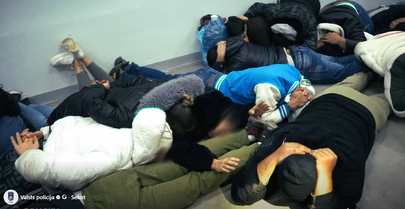 Grupa aizturētu personu guļ uz grīdas policijas operācijas laikā Ukrainā.