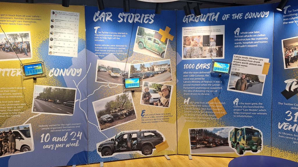Informatīvi stendi ar virsrakstiem "CAR STORIES" un "GROWTH OF THE CONVOY".