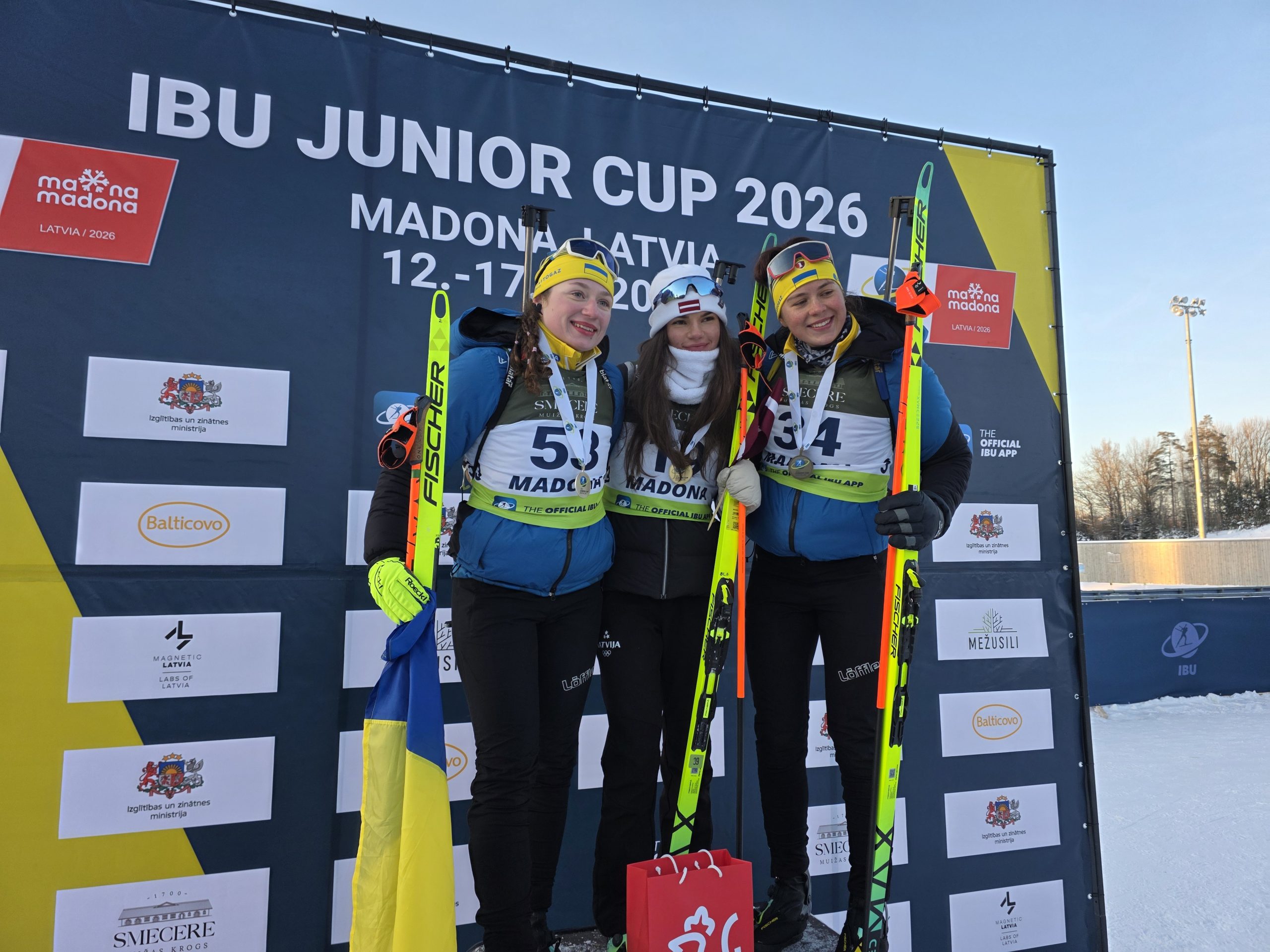 Trīs biatlonistes uz goda pjedestāla Madonā – centrā uzvarētāja Estere Volfa no Latvijas, viņai blakus Ukrainas sportistes.