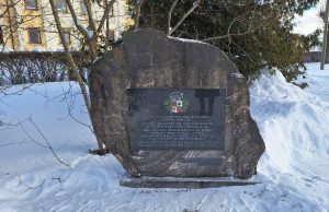 Piemiņas akmens Skrundā par 1919. gada kauju un Latvijas karoga pacelšanu ziemā.