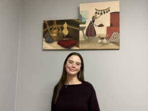 Jauna māksliniece pie saviem darbiem ar sadzīves un tautas kultūras motīviem