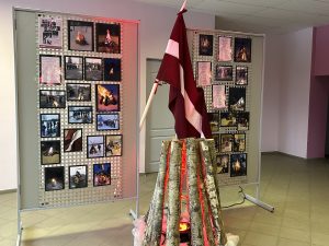 Latvijas karogs un simbolisks ugunskurs pie ziemas pasākuma fotoizstādes