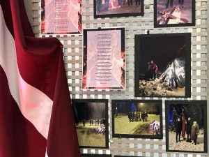 Latvijas karogs pie barikāžu atceres fotoizstādes ar ugunskura attēliem