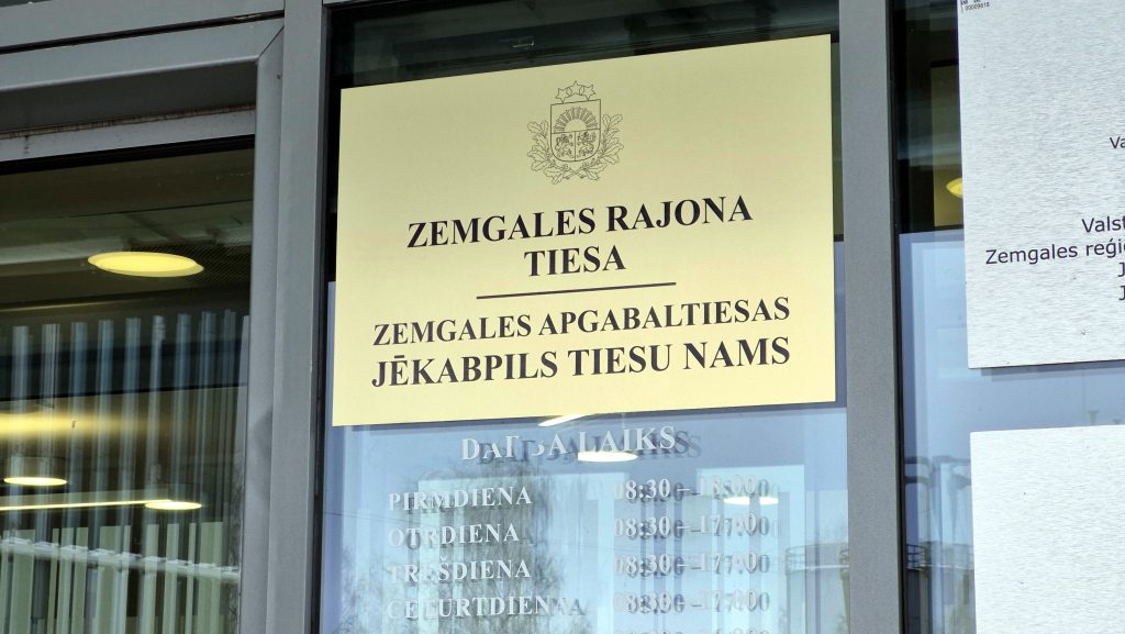 Informatīva plāksne uz stikla durvīm: Zemgales rajona tiesa un Zemgales apgabaltiesas Jēkabpils tiesu nams.