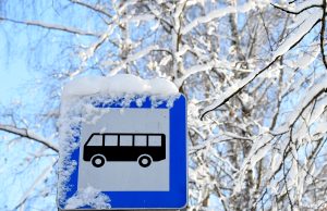Ar sniegu klāta autobusa pieturas zīme ziemā