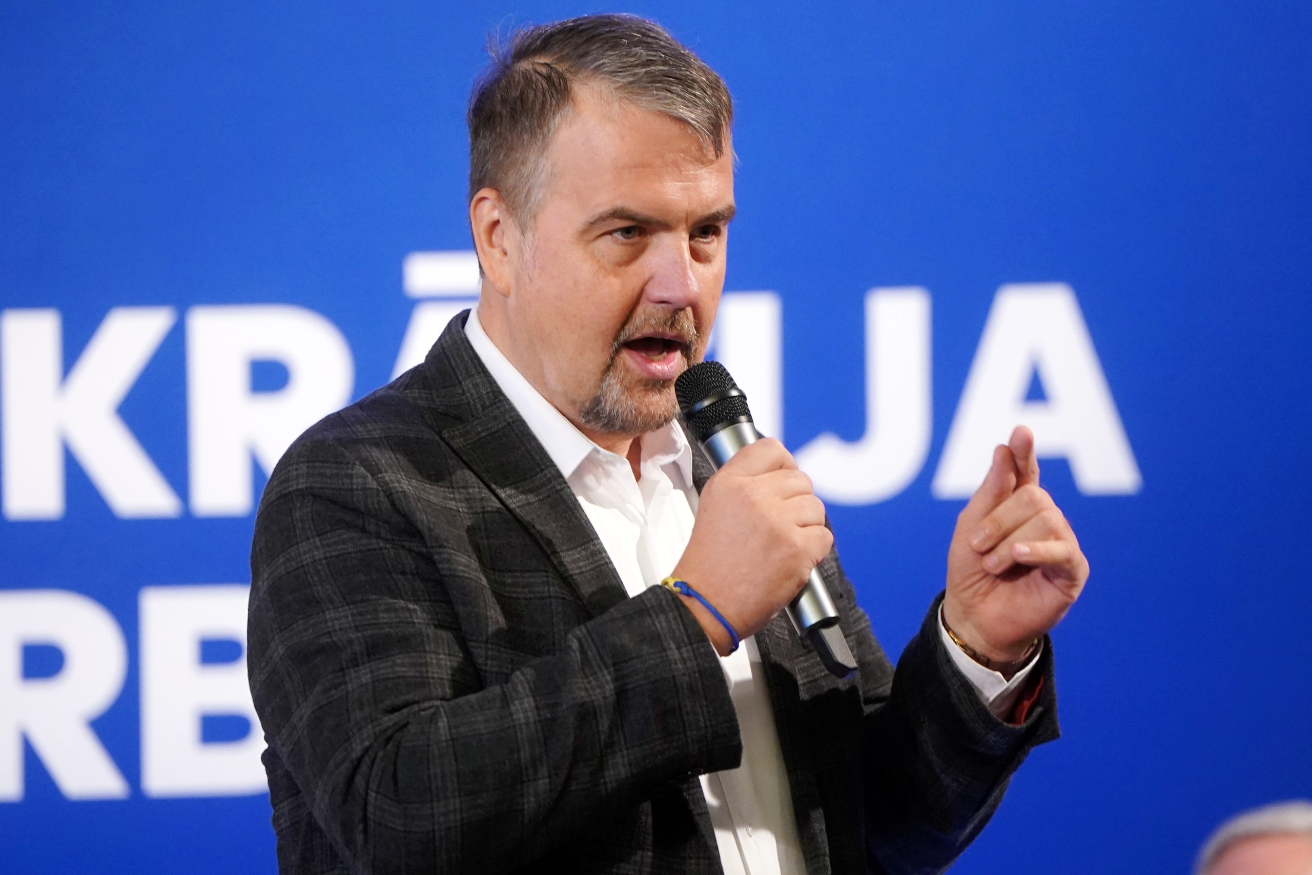 Ivars Ijabs uzstājas ar runu, turot rokā mikrofonu