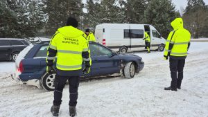 Valsts policijas inspektors un CSDD darbinieks Jēkabpilī veic apturētas automašīnas tehnisko pārbaudi ceļa malā.