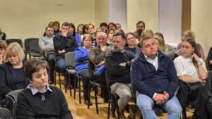 Iedzīvotāji klausās sapulci un diskusiju sabiedriskā sanāksmē