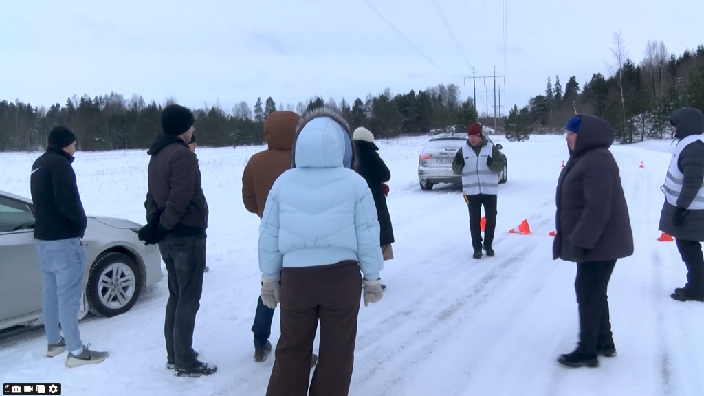 Autovadītāju grupa uz sniegotas trases klausās CSDD drošas braukšanas instruktora norādījumos.