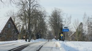 Ceļazīme ar uzrakstu “Sēdere” pie apdzīvotas vietas ziemas apstākļos