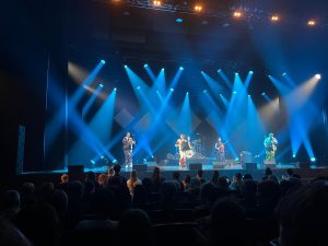 Postfolkloras grupa "Rikši" uzstājas uz skatuves Latgales vēstniecībā GORS zilu prožektoru gaismā.