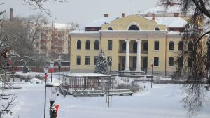 Valkas pilsētas skats ziemā ar sniegotu parku un ēkām