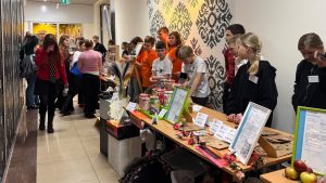 Skolēnu mācību uzņēmumu tirdziņš “Cits bazārs” Jēkabpilī – jaunieši pie stendiem prezentē un pārdod savus produktus.