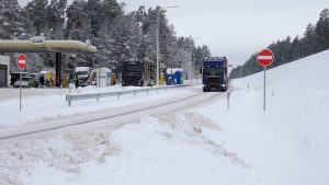 Kravas automašīnas ziemas apstākļos autoceļa malā pie degvielas uzpildes stacijas.