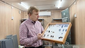 Pētnieks Maksims Balalaikins rāda koka kasti ar entomoloģisko kolekciju.