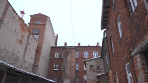 Daudzdzīvokļu māju iekšpagalms ar nolietotām ķieģeļu ēku fasādēm ziemā