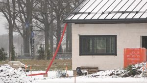Nepabeigta privātmāja ziemas apstākļos ar būvmateriāliem pagalmā