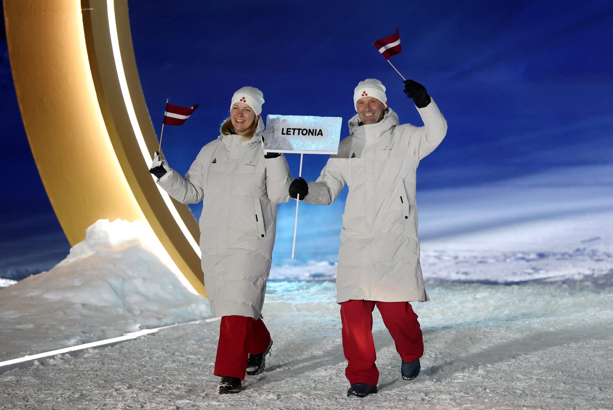 Latvijas delegācijas pārstāvji ar uzrakstu “Lettonia” ziemas olimpisko spēļu atklāšanas ceremonijā Livinjo