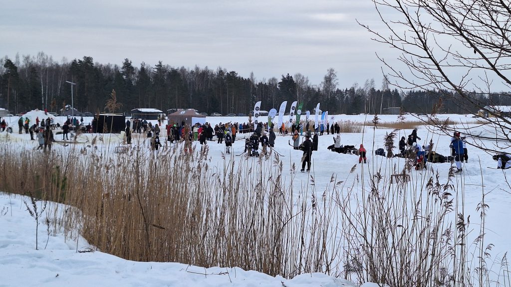 Ziemas festivāla dalībnieki un skatītāji pulcējušies sniegotā teritorijā pie āra aktivitātēm Mārupē.