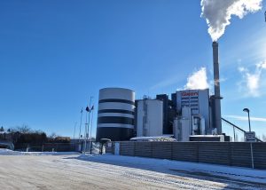 Biomasas koģenerācijas stacija Jelgavā ar dūmeni un uzņēmuma “Gren” logo ziemas laikā.