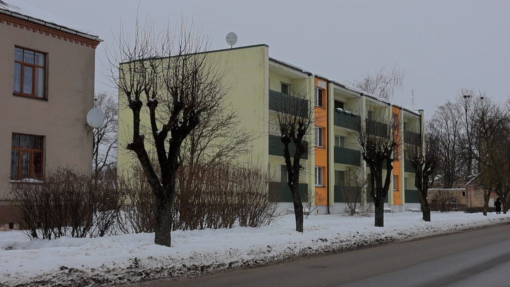 Daudzdzīvokļu ēka Aucē pie pilsētas ielas ziemā